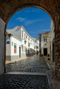 Der Torbogen und die Pflasterstraße Arco da Vila in der alten Stadt, Faro, die Algarve, Portugal Der Torbogen und die Pflasterstraße Arco da Vila in der alten Stadt, Faro, die Algarve, Portugal